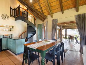 a kitchen and dining room with a table and chairs at Montusi Self-Catering Cottages in Bergville