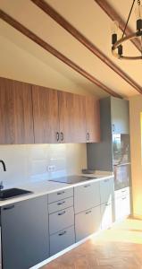a kitchen with white counters and wooden cabinets at Casas do Monte I - T3 