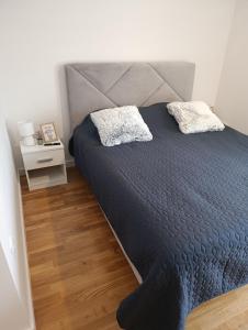 a bedroom with a large bed and a night stand at Apartman ANATEO Istocno Sarajevo in Vranješ