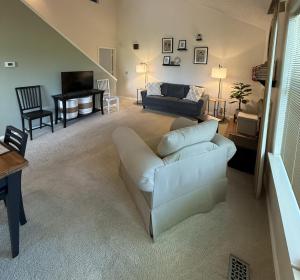 a living room with a white couch and a television at The Treehouse on Table Rock in Eureka Springs