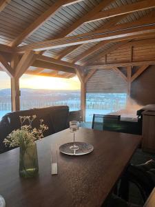 a wooden table with a glass of wine on it at Widokówka Radostowa in Podmąchocice