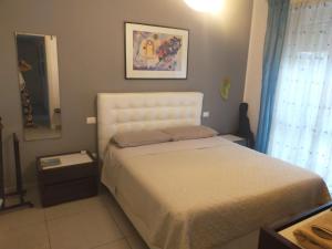a bedroom with a white bed and a mirror at Focolare domestico in Milan