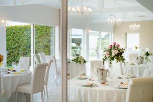a dining room with white tables and white chairs at Villa Natia in Mottola