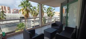 a balcony with chairs and a view of palm trees at Chez Gilles in Pointe-à-Pitre