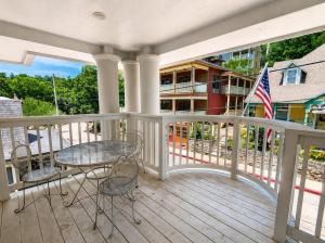 a porch with a table and chairs and a flag at Springs Wish in Eureka Springs