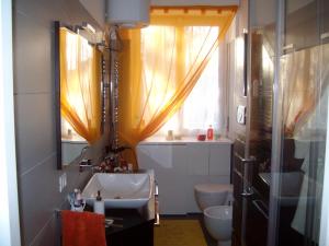 a bathroom with a sink and a toilet and a window at Focolare domestico in Milan