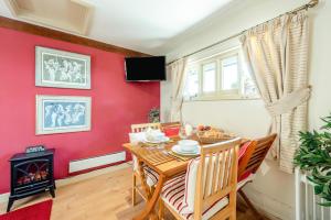a dining room with red walls and a table and a fireplace at 1 Bed in Battle oc-bt112 in Battle