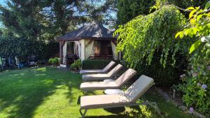 a group of lounge chairs in a yard with a gazebo at Villa Maritima in Grzybowo