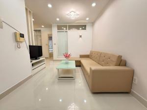 a living room with a couch and a tv at StayX Sky Garden in Ba Ria
