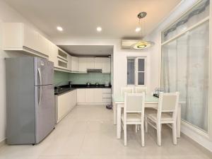 a kitchen with a table and chairs and a refrigerator at StayX Sky Garden in Ba Ria