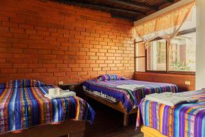 a room with two beds and a brick wall at PatulomaEscape in El Rosario +64 photos