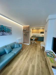 a living room with a blue couch and a kitchen at Apartamentos Las Alas in Cartes