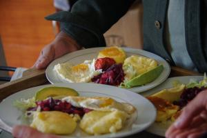 a person holding two plates of food on a table at PatulomaEscape in El Rosario