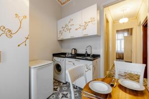 a kitchen with a washing machine and a wooden table at Felicity Palace Sirkeci in Istanbul