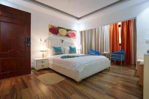 a hotel room with a bed and a table at Cinq Cent Vingt Hotel & Residence in Abidjan +7 photos
