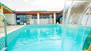 a large swimming pool with a water fountain at Cinq Cent Vingt Hotel & Residence in Abidjan