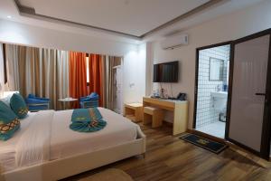 a hotel room with a bed and a bathroom at Cinq Cent Vingt Hotel & Residence in Abidjan