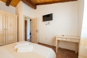 a bedroom with a bed and a tv on the wall at Agriturismo Cirra in Tertenìa
