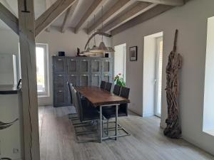a dining room with a wooden table and chairs at Les Jardins du Bateau in Vals-les-Bains