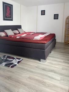 a bed in a bedroom with a wooden floor at Charlottenhöhe Apartment in Rottweil