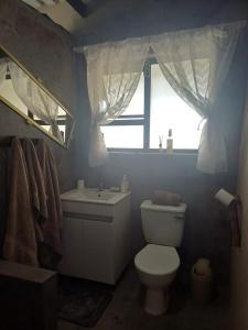a bathroom with a toilet and a sink and a window at BosSpoke Bush Lodge in Thabazimbi +7 photos