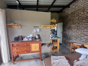 a room with a wooden dresser and a brick wall at BosSpoke Bush Lodge in Thabazimbi
