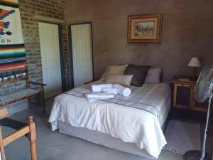 a bedroom with a bed with towels on it at BosSpoke Bush Lodge in Thabazimbi