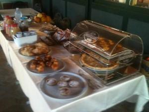 a table with plates of pastries and donuts on it at Hotel Grotte in Mongiove +8 photos