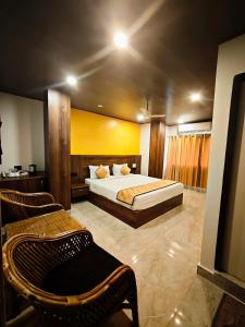 a bedroom with a bed and two chairs in it at The Mangrove Cove "200Mtrs from Beach" in Shādipur