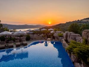 a pool at a resort with a sunset in the background at Villa EUPHORIA in Ridovo