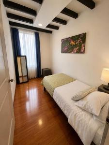 a bedroom with a bed in a room with wooden floors at Hostel Casa Unicentro in Bogotá