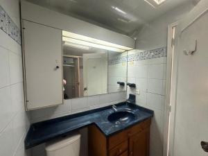 a bathroom with a blue sink and a mirror at Hostel Casa Unicentro in Bogotá