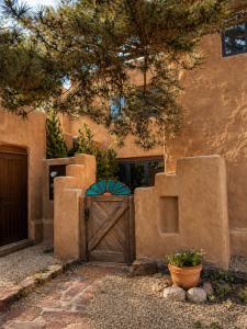 a house with a wooden gate and a tree at Las Brisas de Santa fe in Santa Fe