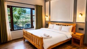 a bedroom with a large bed and a large window at Summer Stays Boho in Bhīm Tāl