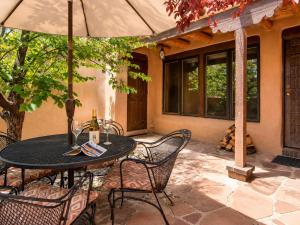 a table and chairs with an umbrella on a patio at Las Brisas de Santa fe in Santa Fe