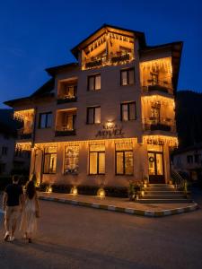 a man and woman walking in front of a building at Advel Guest House-Rila Mountain Retreat in Madzhare