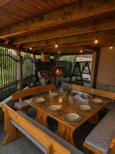 a wooden table with plates on it on a patio at Advel Guest House-Rila Mountain Retreat in Madzhare