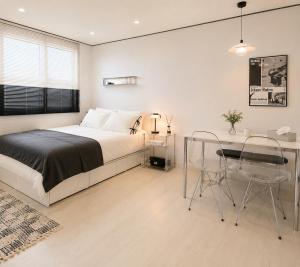 a bedroom with a bed and a table and chairs at Yoonsul Gwangalli 3beds for 4guests in Suyŏng