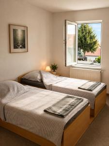 two beds in a bedroom with a window at Pension Zum Rödereck in Zeithain