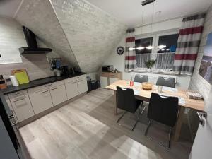 a kitchen with a table and chairs in a room at Apartment Grieshop in Dinklage