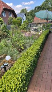 a garden with yellow flowers next to a brick path at Apartment Grieshop in Dinklage