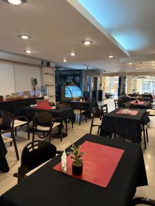 a restaurant with black tables and chairs and a tv at Del Fundador in Córdoba