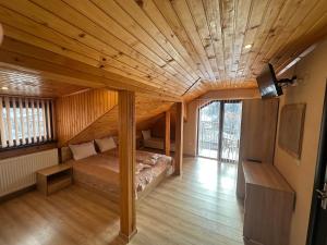 a bedroom with a bed in a room with wooden ceilings at Advel Guest House-Rila Mountain Retreat in Madzhare