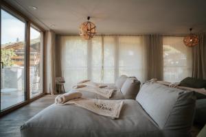 a large bed in a room with a large window at Hotel Tofana in San Cassiano