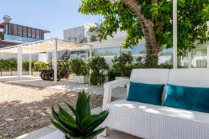 a white couch with blue pillows on a patio at Affittacamere Mare Poetto Cagliari in Quartu Sant'Elena
