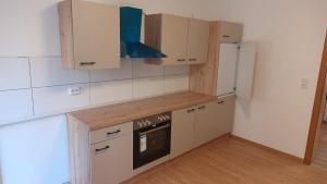 a kitchen with white cabinets and a stove top oven at Werrapark Apart Heubach in Masserberg
