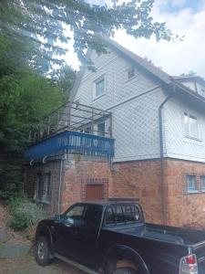 a black truck parked in front of a brick house at Werrapark Apart Heubach in Masserberg