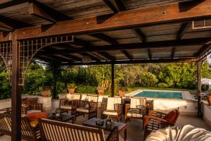 an outdoor patio with a wooden pergola and a swimming pool at B&B Villa Giuliana in Arnesano