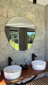 two white bowls on a table in front of a mirror at Cabana No Lago in Rancho Queimado +12 photos