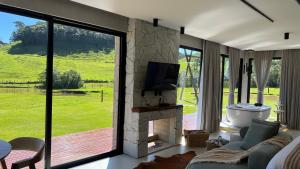 a living room with a fireplace and a tv at Cabana No Lago in Rancho Queimado